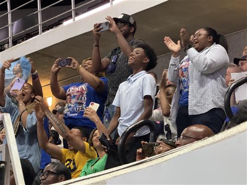 family cheering from upper balcony